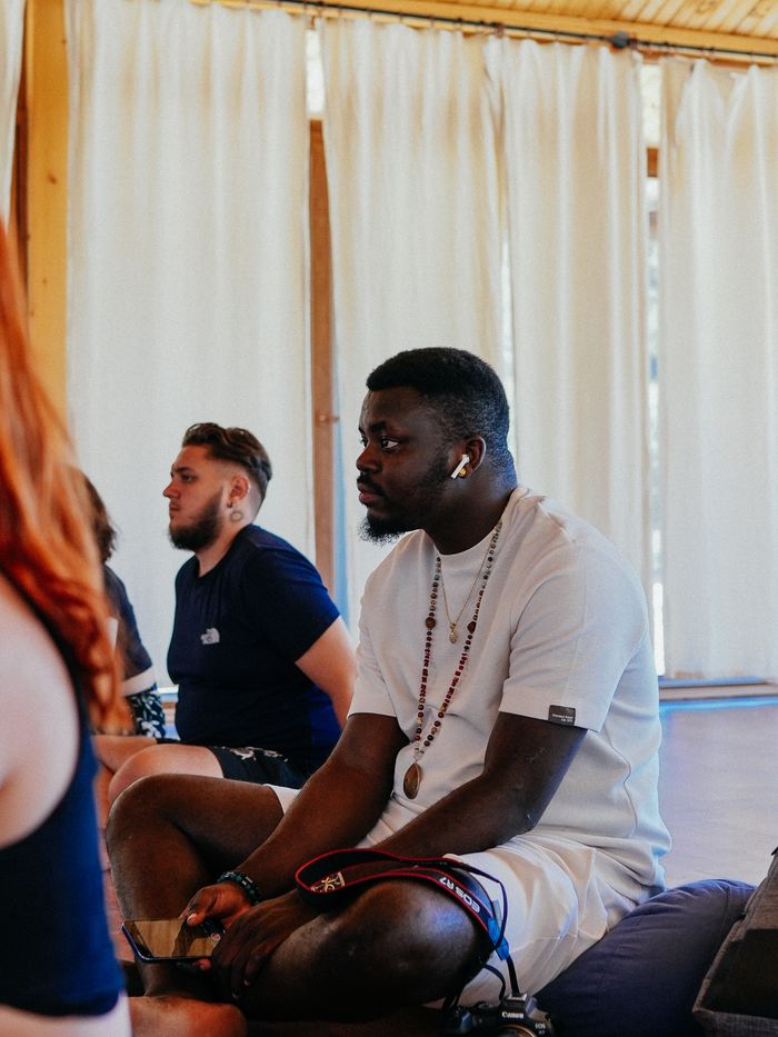 A diverse group of adults sitting and meditating indoors, focusing on mindfulness.