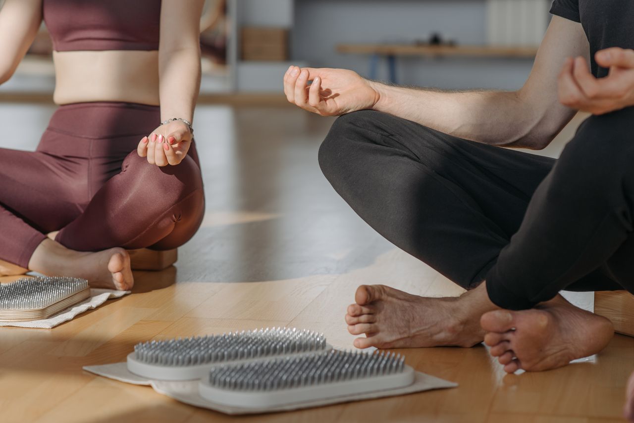 A close-up of people meditating on sadhu boards, promoting relaxation and wellness.